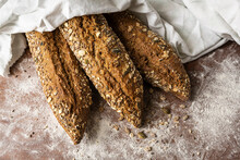 In The Foreground Of Rustic Bread With Seeds And Grains