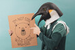 ©  Yistocking - An activist poses with a penguin mask and a banner on a blue background. Climate change concept.