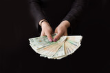 Fototapeta  - Kobieta wyciąga przed siebie ręce pełne pieniędzy, dużo pieniędzy w dłoni