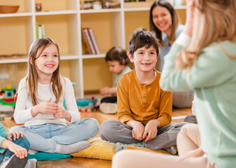 Wall Mural - Active preschool Children Interacting with their Teacher. Teacher-child relationships – Early Learning.  Healthy Learning Environment