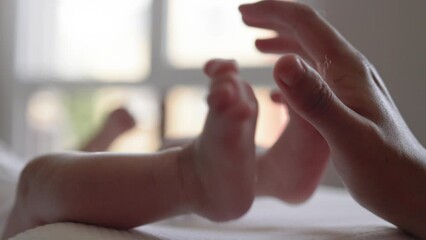 mother holds newborn baby's legs. happy motherhood, parenthood