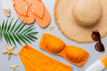Woman Swimwear And Beach Accessories Flat Lay Top View On Colored Background Summer Travel Concept. Bikini Swimsuit, Straw Hat And Seasheels. Copy Space Top View