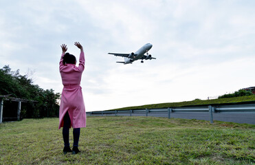 Woman looking at the plane in the sky