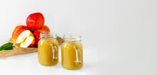 Two Jars Of Baby Food From Apples With Pulp, Apples On The Background Are Red, Vitamin Nutrition For Children, Banner, Space For Text