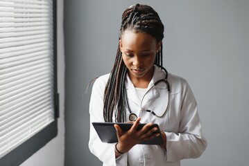 Wall Mural - happy young african female nurse working in office.