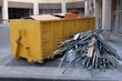Huge heap on metal Big Overloaded dumpster waste container filled with construction waste, drywall and other rubble near a construction site.