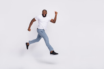 Wall Mural - Photo of excited pretty guy dressed casual t-shirt jumping high running hurry isolated white color background