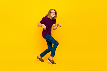 Poster - Full size portrait of positive cheerful person sneaky walking toothy smile isolated on yellow color background