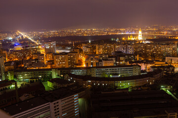 Wall Mural - Ukraine, Kyiv – March 12, 2016: Aerial panoramic view on central part of Kyiv city from a roof of a high-rise building. Night life in a big city. Foggy and rainy weather. 