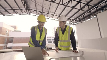 Wall Mural - Two Asian man Civil Engineer and Contractor handshake deal working on the table in construction site. Architect and Builder discuss solve problem together.