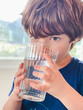© Tamara Sales  - Chils little boy drinking water from a glass cup
