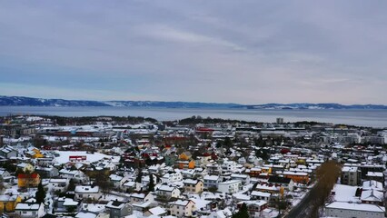 Wall Mural - Trondheim, Norway. Aerial view of the city center in spring in Trondheim, Norway with snow. Aerial view of sea and historical colorful buildings