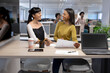 © wavebreak3 - Happy multiracial businesswomen discussing over document while working together at modern workplace