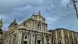 Scenic view from the central square on the Cathedral of Sant Agata, Piazza Duomo, Catania, Sicily, Italy. Birds are flying over the building. Cloudy overcast day in winter. Italian architecture