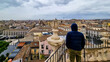 A man standing on the platform of the Church of the Badia di Sant Agata in Catania, Italy, Sicily, Europe. Panoramic view on the the city on a cloudy overcast day. Tourism, sight seeing