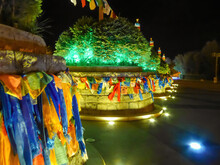 A Close Up On A Colorful Heaps Of Stones (aobao) In Hohhot, Inner Mongolia. The Heap Of Stones Id Decorated With Colorful Prayer Flags And Lit With Green Lights. Darkness Around It. Spirituality