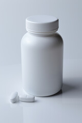 Wall Mural - white plastic medicine jar and two white pills. light background