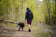 Mężczyzna spacerujący ze swoim psem w zielonym lesie