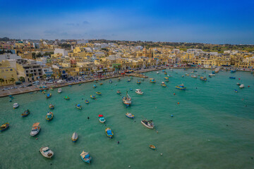 Sticker - Aerial panoramic view of Marsaxlokk - small, traditional fishing village in the South Eastern Region of Malta with many colorful fisherman boats in the bay