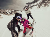 Fototapeta Sawanna - Happy young family taking a selfie at skiing resort.
