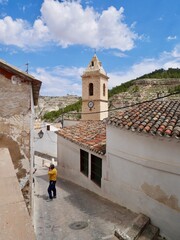 Back street and bell tower of church of San Andres, Iglesia de San Andres, in Alcala del Jucar, province of Albacete, Spain.
