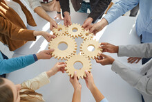Hands Close-up Of Group Multiethnic Business People Connect Wooden Gears In The Center. Arial View. Success Cooperation Teamwork Concept, Connection Technology Concept