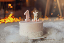 Birthday Candle As Number One On Top Of Sweet Cake And Pink Unicorn On Table, Concept Image
