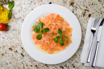 Wall Mural - Salmon carpaccio on a white plate on marble table top view
