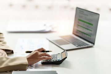 Close up Business woman hand using calculator to calculate the company's financial results and budget. Account Audit Concept.