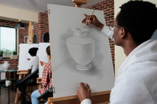 African American Student Attending Art Lesson Working At Creative Artwork Drawing Vase Model Using Graphic Pencil In Creativity Studio. Multiethnic Team Sketching Draw. Creative Concept