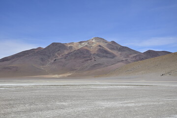 Lake between the mountains, with pink flamingo. Off-road tour on the salt flat Salar de Uyuni in Bolivia