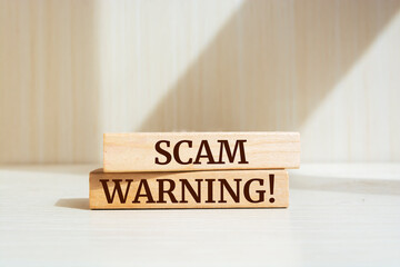 Wooden blocks with words 'Scam Warning'. Business, technology, internet concept.