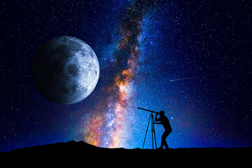 Wall Mural - man looking at the stars and moon through a telescope
