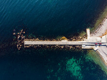 Top Above Scenic Aerial View Of Concrete Breakwater Wall In Clean Blue Deep Sea Or Ocean Water Shore Beach. Drone Pov Wave Storm Protection Rock Pier Beautiful Turquoise Pond Bay. Coastal Background