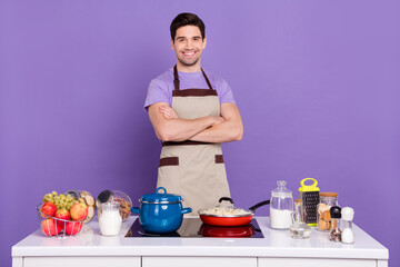 Photo of pretty confident guy wear grey apron arms crossed ready cook tasty dish isolated violet color background