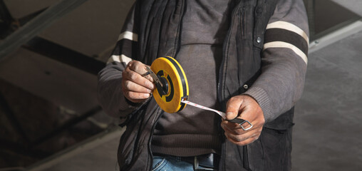 Wall Mural - Caucasian worker holding measure tape.