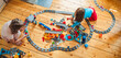 © velirina - Girls, sisters play kids constructor, build toy railway, railroad by Bricks bricks,blocks. Train, locomotive,rails, traffic light. Children activity at home in playroom.Development of fine motor skills
