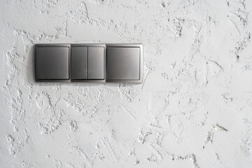 Grey light switches on textured wall in room