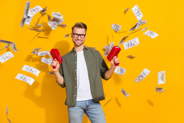 Sticker - Portrait of attractive cheerful rich guy shooting us dollars loan exchange isolated over bright yellow color background