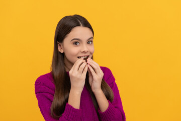 Eat it, enjoy it. Happy girl bite chocolate. Sweet tooth yellow background. Enjoy chocolate eating