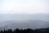 Fototapeta Na ścianę - Panoramic view from local mountain Uetliberg with valley, village, agricultural fields and Swiss Alps in the background on a blue cloudy spring day. Photo taken April 14th, 2022, Zurich, Switzerland.
