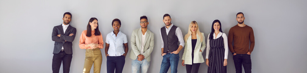 young diverse fashion models posing against gray background. banner with group portrait of confident