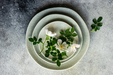 Overhead View Of A Stack Of Plates With White Wild Roses