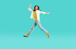© Studio Romantic - Yay. Happy pretty woman having fun in comfortable wear. Full length portrait excited ecstatic crazy attractive young girl with long brunette hair in modern yellow T shirt and blue jeans jumping in air