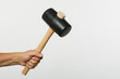 Hand holding a rubber hammer with a wooden handle 