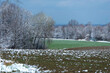 Zaorane pole pokryte śniegiem po przejściu burzy śnieżnej.