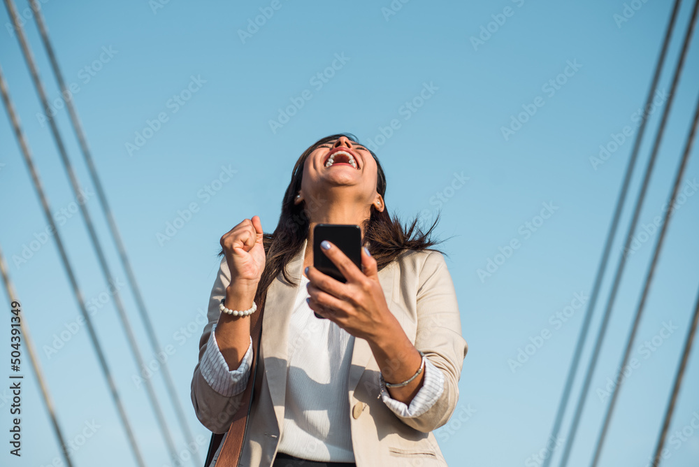 portrait of a businesswoman laughing to the sky in happiness because she won an award