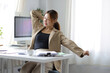 © Wasan - A business woman working in an office stretches to relax from work during breaks.