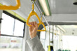 Woman holding handgrip handle in public transport, closeup
