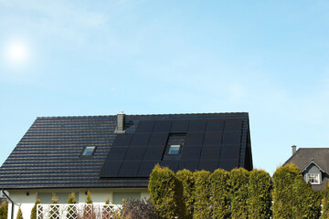 house with installed solar panels on roof. alternative energy